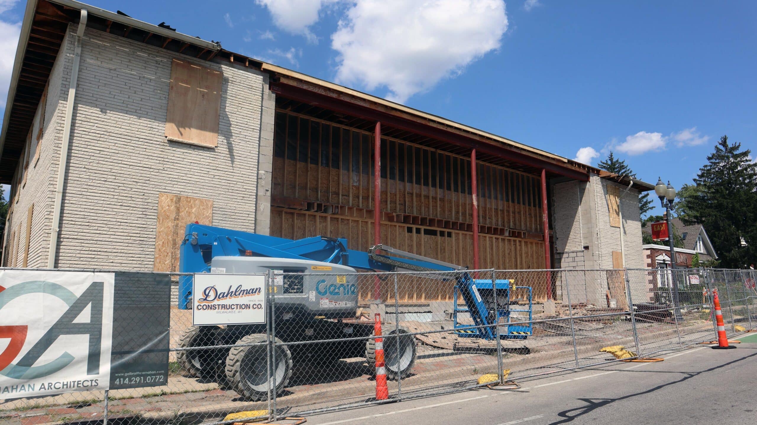 Façade during construction with framing exposed and lift on site.